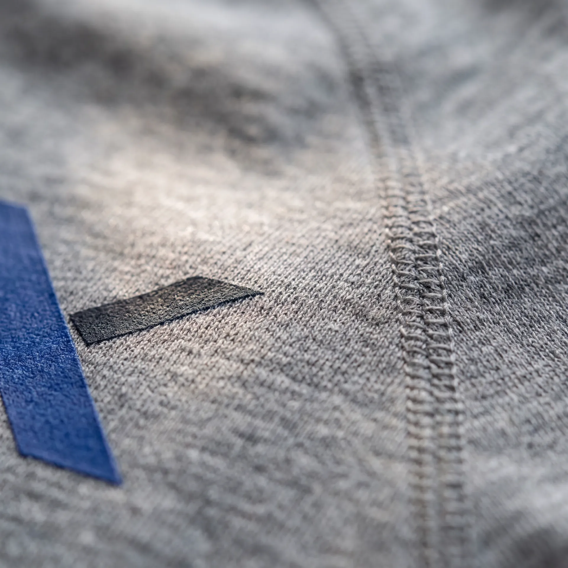 Macro detail of fabric, stitching and logo on the Core Performance Tee