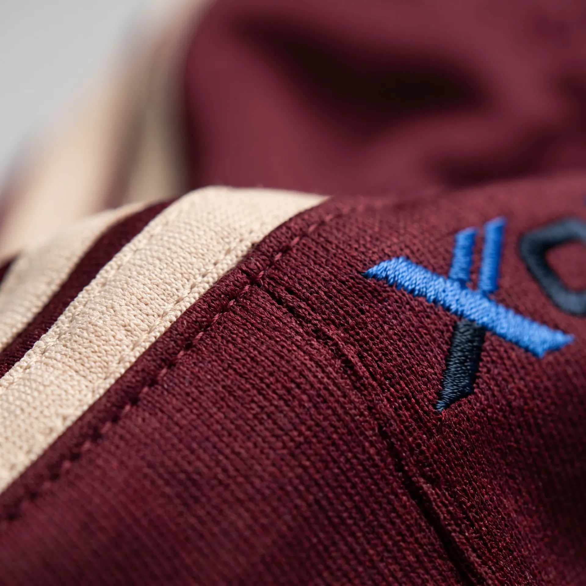 Macro detail of fabric, stitching and logo on the Retro Tricot Tracksuit