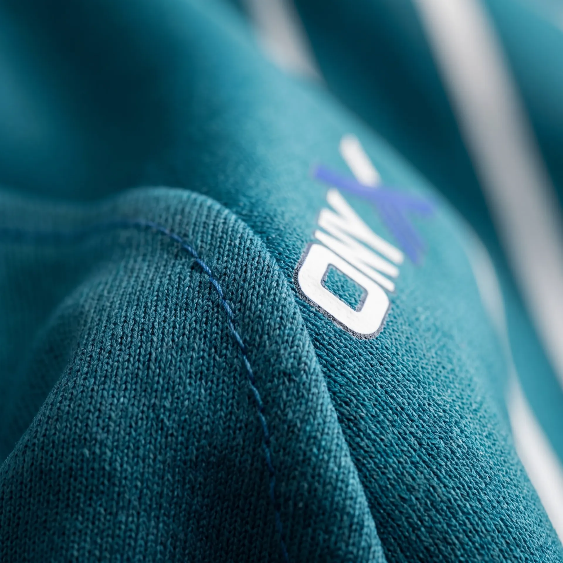 Macro detail of fabric, stitching and logo on the Rally Cap-Sleeve Jersey