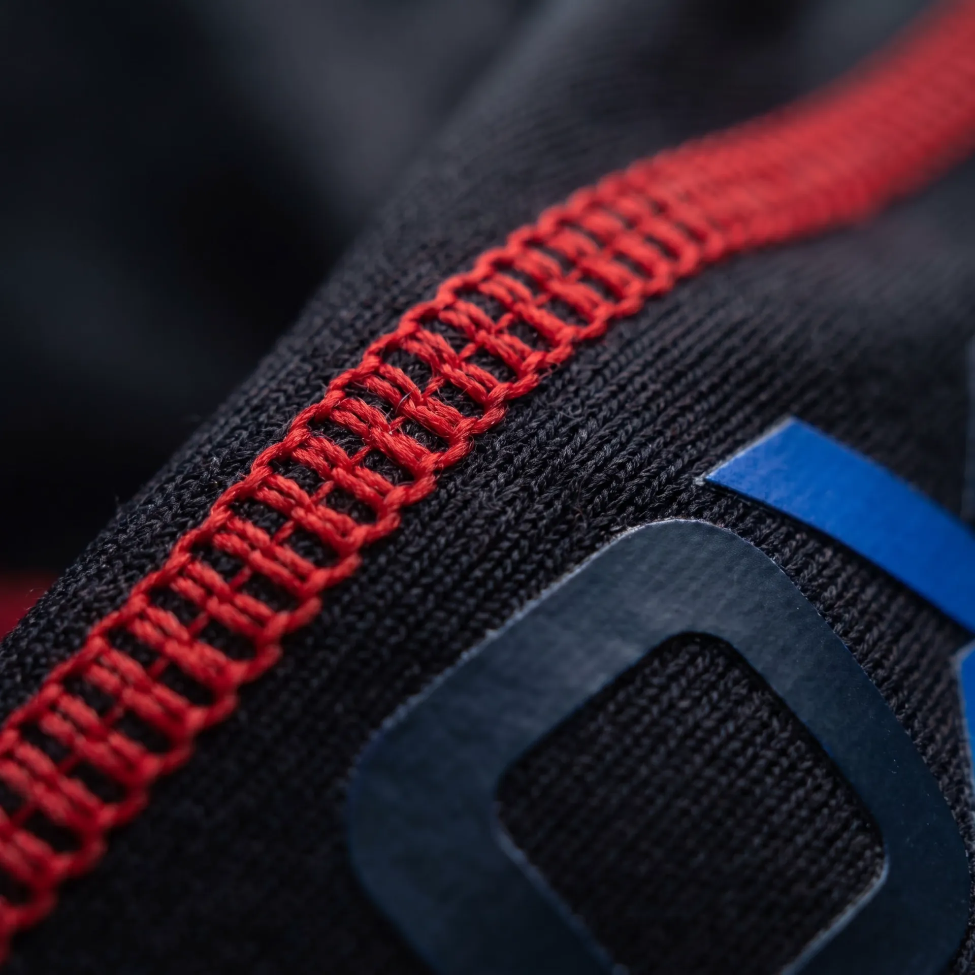Macro detail of fabric, stitching and logo on the Clinch Rash Guard