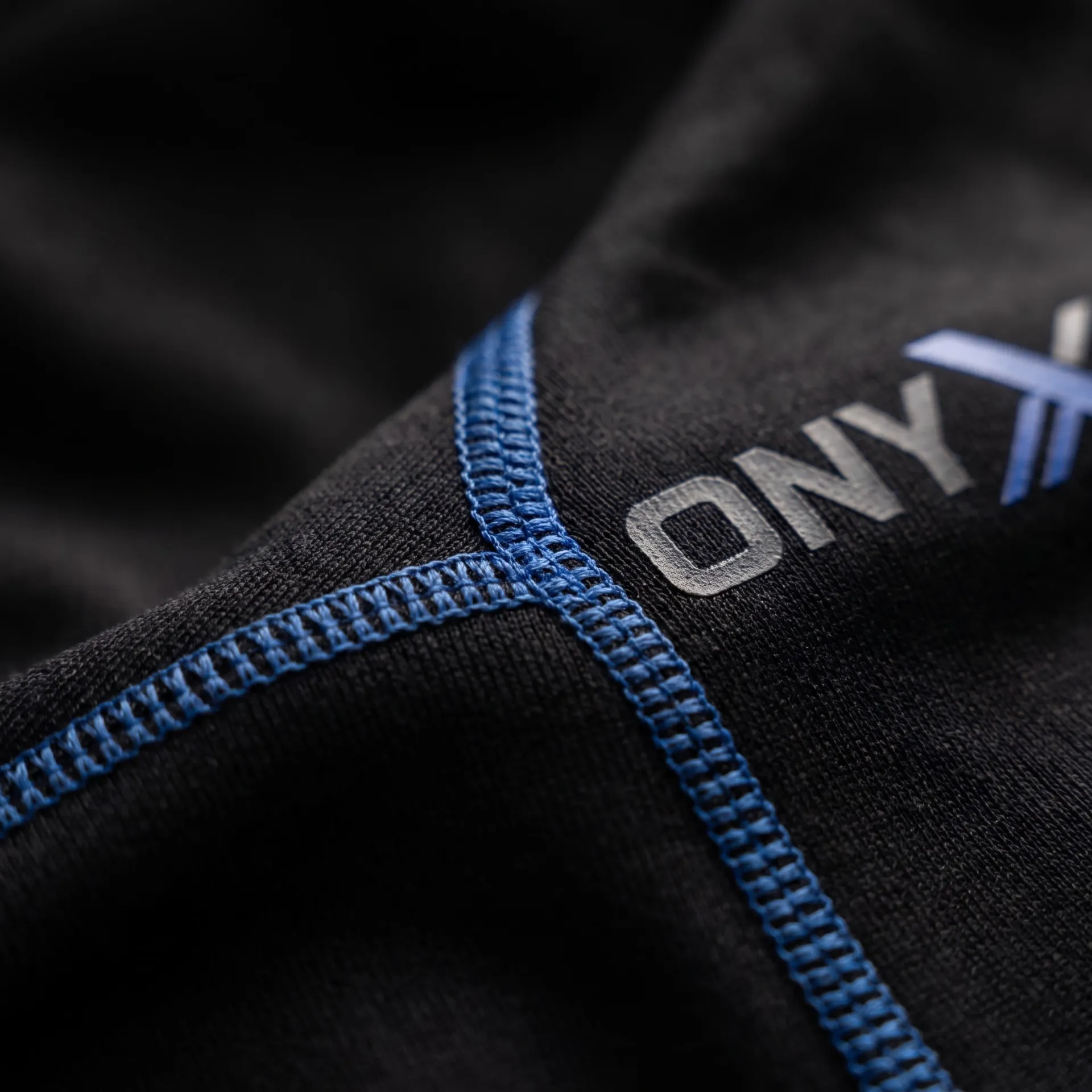 Macro detail of fabric, stitching and logo on the Second-Skin Base Layer