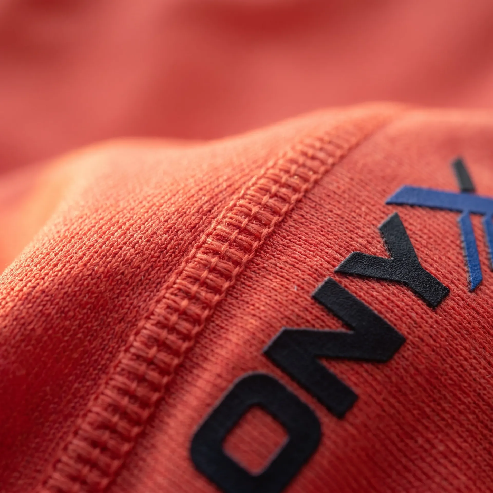 Macro detail of fabric, stitching and logo on the Tempo Running Singlet
